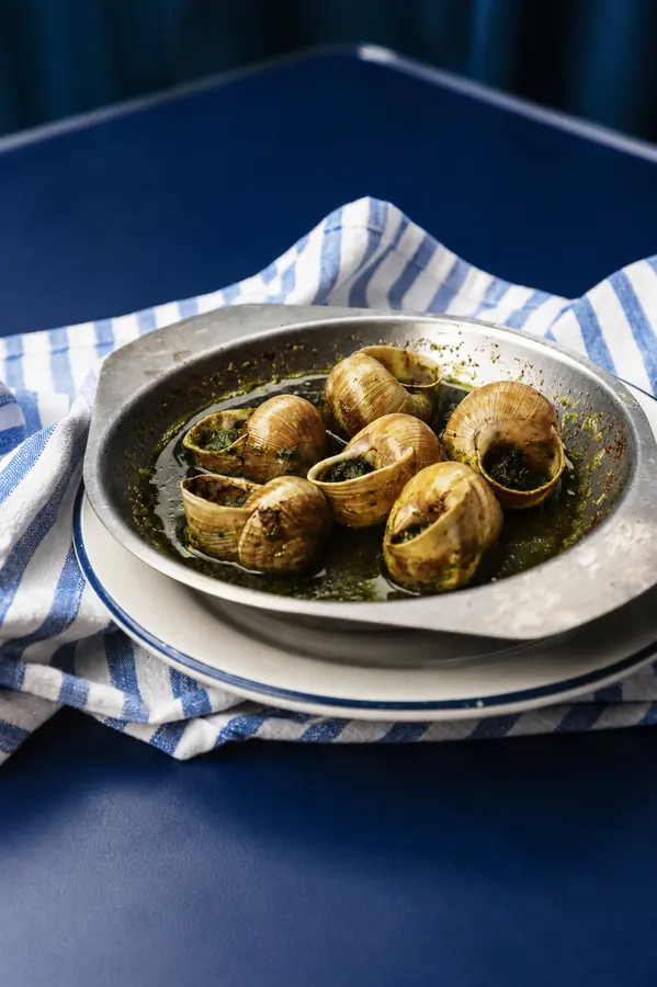 Caracoles a la mantequilla sobre mantel de rayas azules