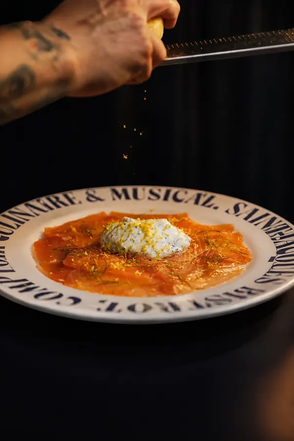 Chef rallando sobre un plato Comptoir con salsa roja