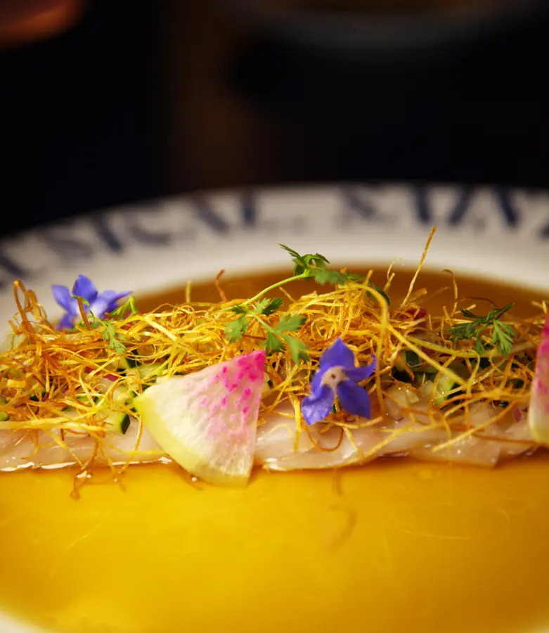 Crudo con flores y puré cítrico en plato Comptoir