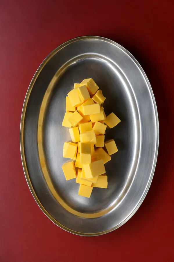 Cubos de mango sobre charola de plata, fondo rojo