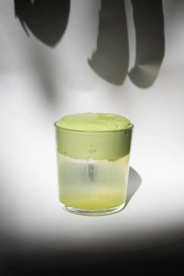 Bebida verde en vaso, luz y sombra