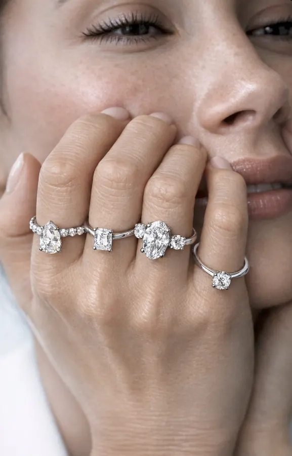 Modelo con cuatro anillos de compromiso junto al rostro