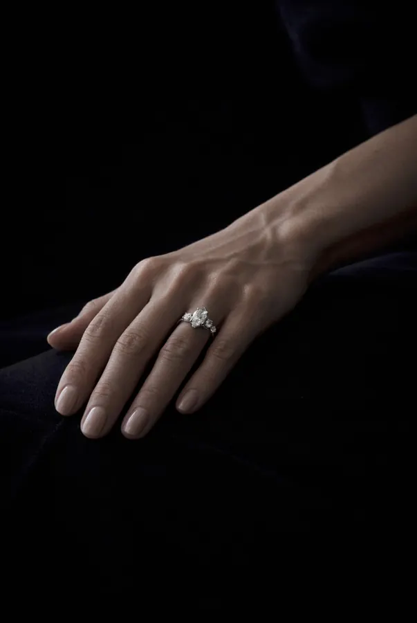 Mano con anillo solitario sobre fondo negro