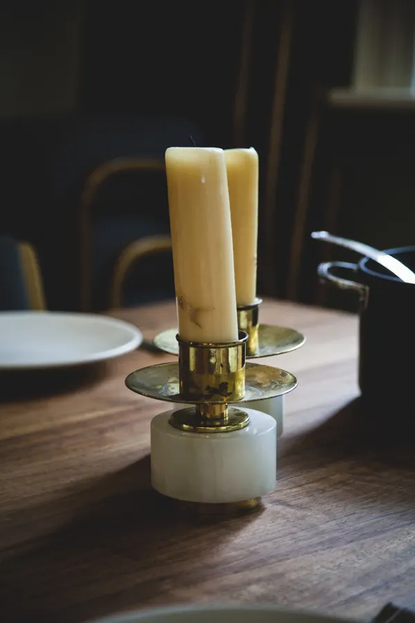Candelabro de latón con velas sobre mesa de madera