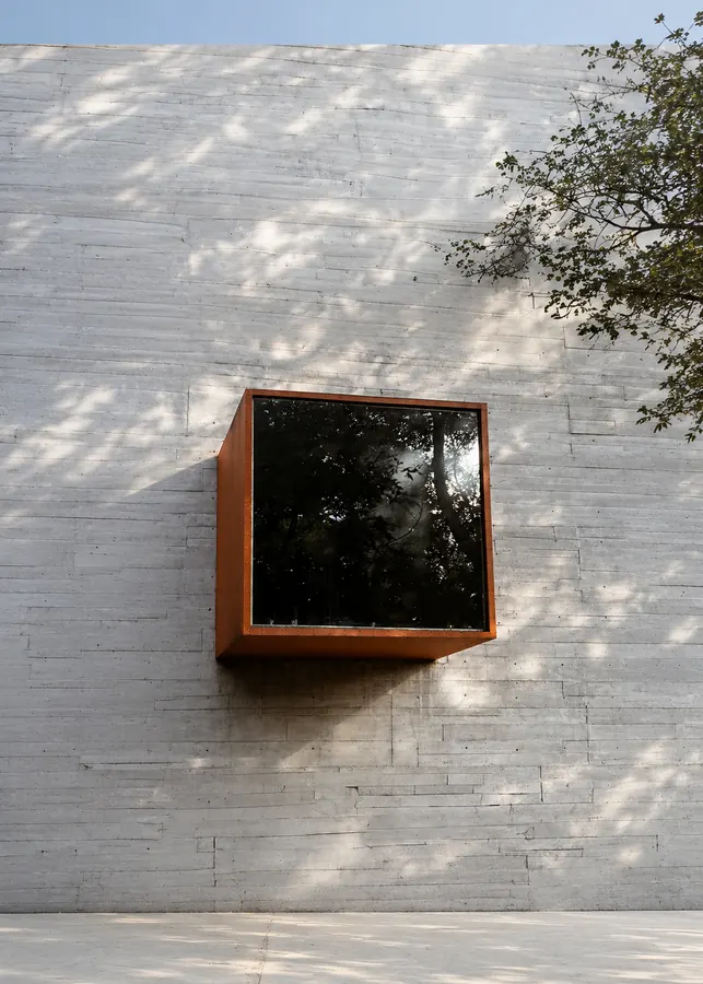 Ventana de acero en voladizo sobre muro de concreto
