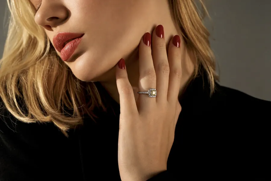 Modelo con anillo y uñas rojas, luz lateral